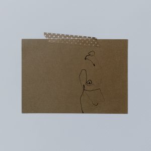 Postkarte aus Kraftkarton mit Tape an der Wand befestigt. Postkarte zeigt filigrane one line illustration einer nakten Frau